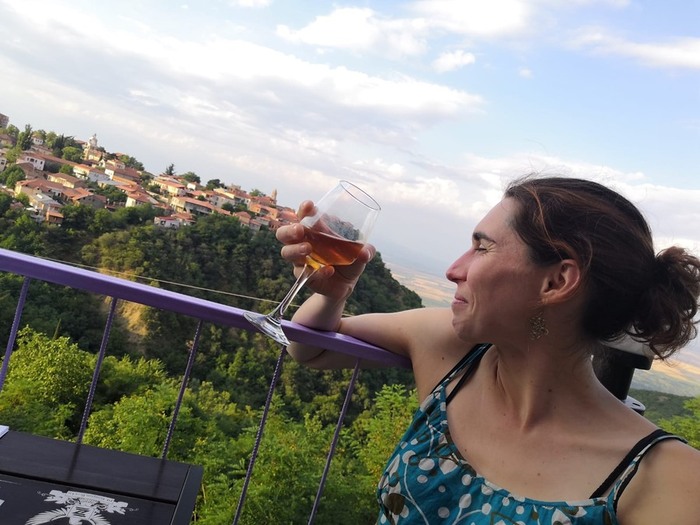 Aline sur une terrasse avec un verre de vin